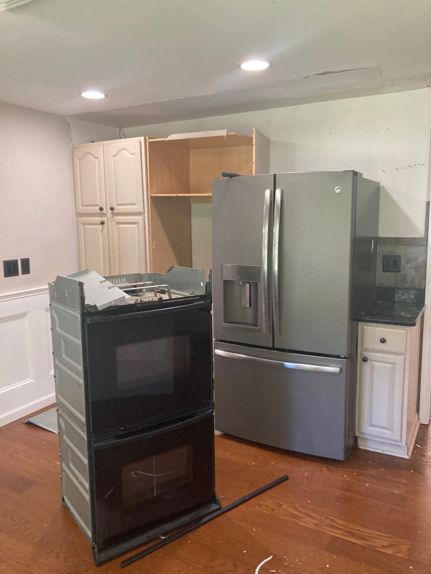 During kitchen renovation: exposed wall above refrigerator and removed oven awaiting cabinet work