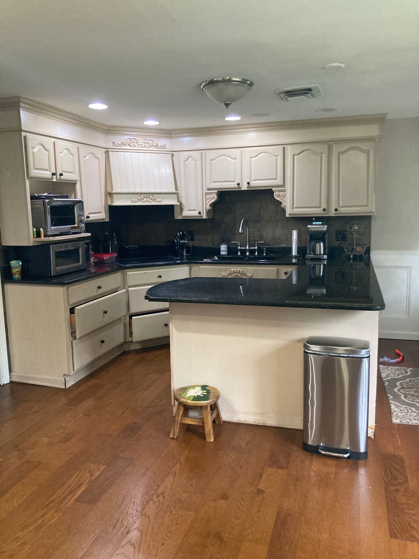 Before kitchen renovation: beige cabinets, dark countertops and a central island